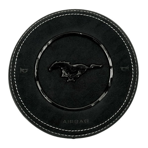 Custom black Alcantara airbag cover for 2015–2023 Ford Mustang S550 with white stitching, a forged carbon fiber pony emblem, and forged carbon fiber trim ring.