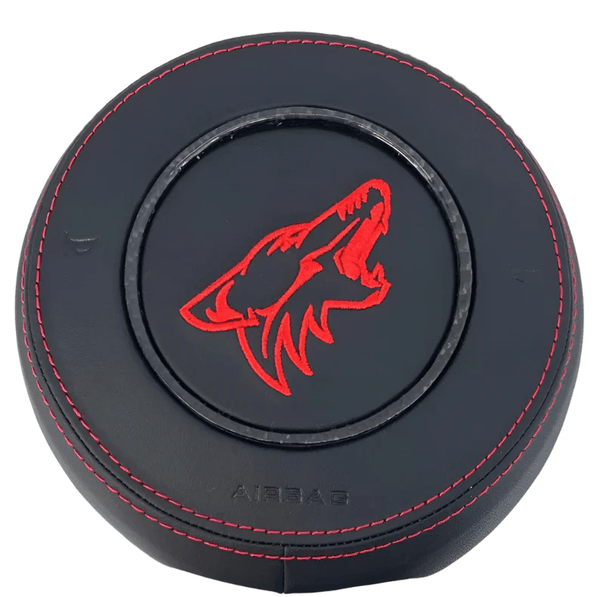 2015-2023 Ford Mustang S550 custom black leather airbag cover with red Coyote emblem, red stitching, and carbon fiber trim ring