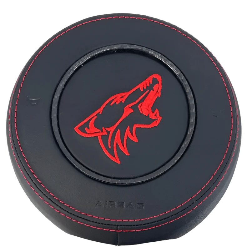 2015-2023 Ford Mustang S550 custom black leather airbag cover with red Coyote emblem, red stitching, and carbon fiber trim ring
