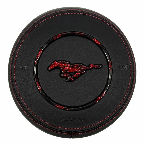Custom black leather airbag cover for 2015–2023 Ford Mustang S550 with red stitching, red-flake forged carbon fiber pony emblem, and matching forged carbon trim ring.