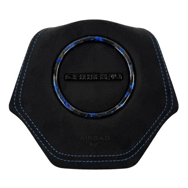 2016–2024 Chevrolet Camaro 6th-gen custom black Alcantara airbag cover with blue contrast stitching, blue-flake forged carbon fiber trim ring, and black Camaro wordmark.