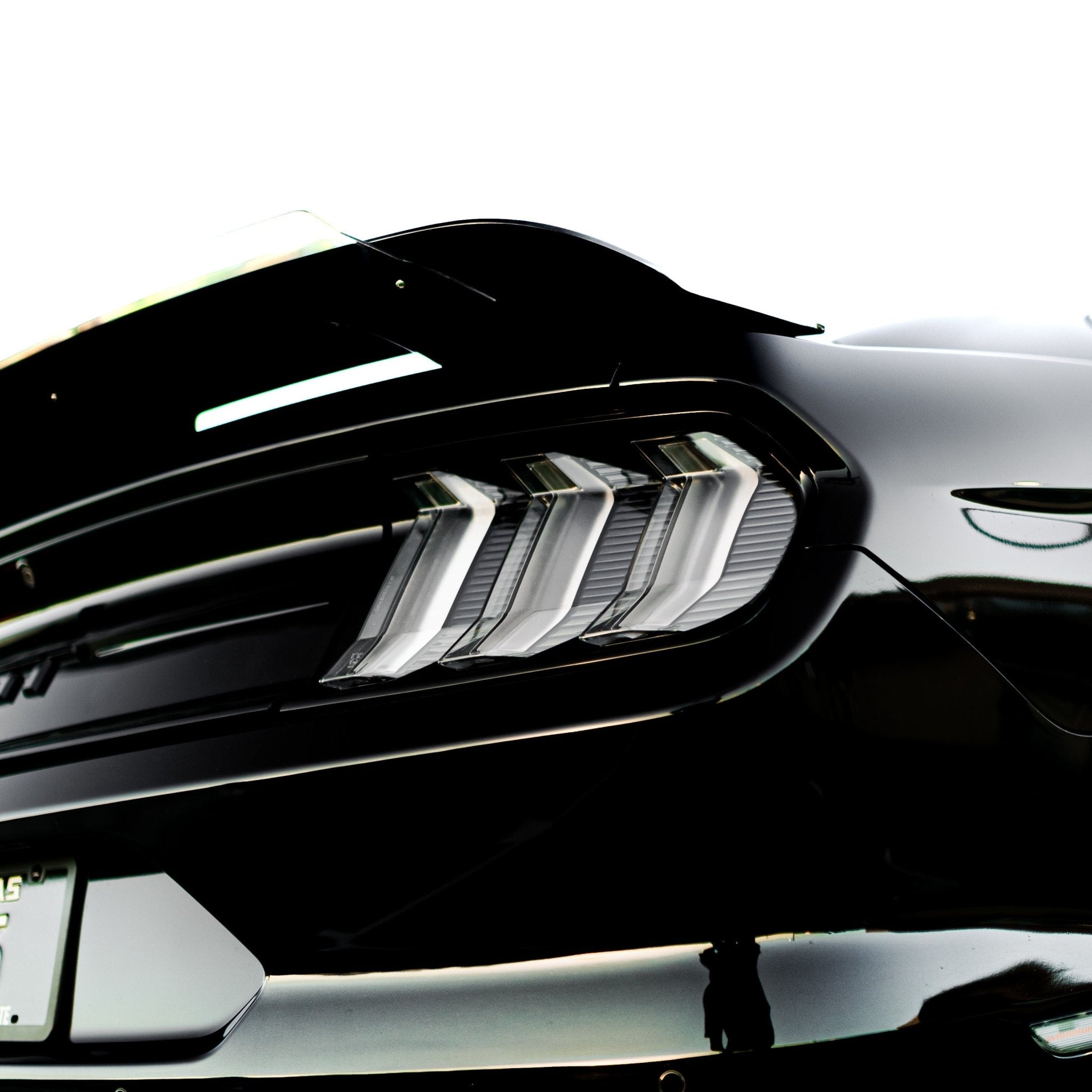 2015-2023 S550 Mustang clear lens Euro LED tail lights installed on black Mustang rear with triple-bar lenses